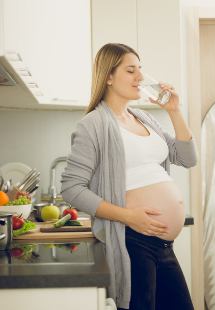 キッチンで水を飲んで妊娠中の女性の肖像画 - 写真・画像