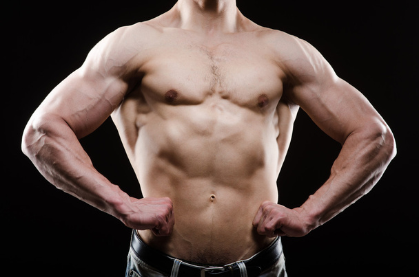 Muscular man posing in dark studio - Fotografie, Obrázek