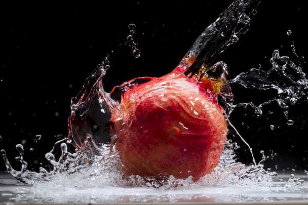 Pomegranate splashing water - Foto, afbeelding