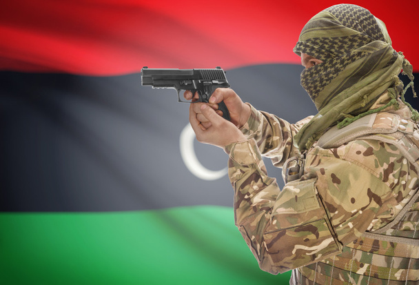Male in muslim keffiyeh with gun in hand and national flag on background - Libya - Zdjęcie, obraz