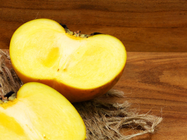 ripe sweet persimmons on wooden table - Φωτογραφία, εικόνα