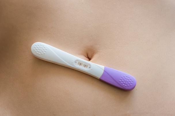 Teste de gravidez positivo na barriga
 - Foto, Imagem