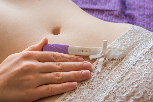 Mulher grávida segurando teste de gravidez positivo
 - Foto, Imagem