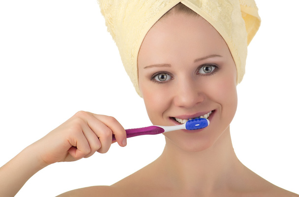 Jeune femme en bonne santé dans une serviette nettoie les dents avec une brosse à dents
 - Photo, image