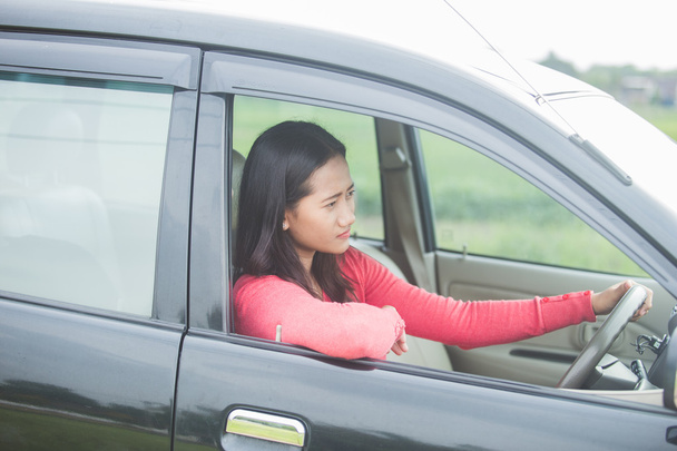 Young Asian woman driving a car with serious face  - Fotó, kép