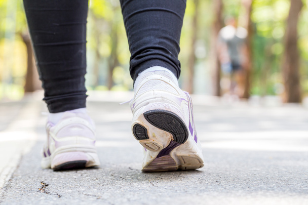 Closeup of running shoes of woman jogging in park - Valokuva, kuva