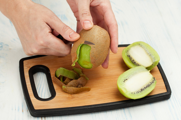 Κοπή το μαχαίρι φρούτων σε μια σανίδα - Φωτογραφία, εικόνα