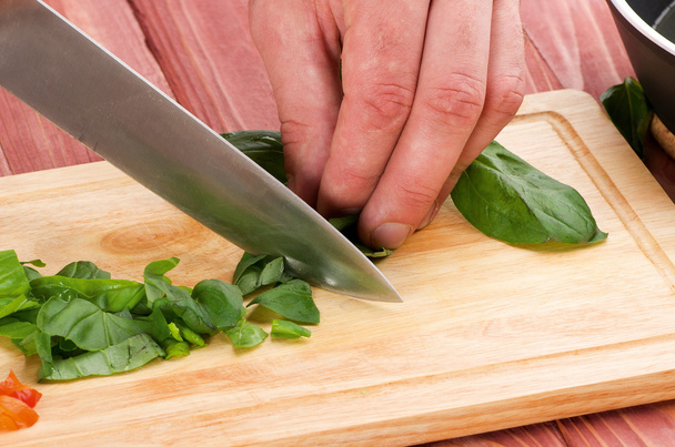 Couper les légumes avec un couteau de cuisine sur la planche
 - Photo, image