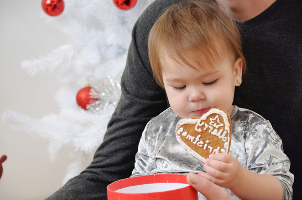 クリスマス近くのクッキーを食べてかわいい赤ちゃん女の子の肖像画  - 写真・画像