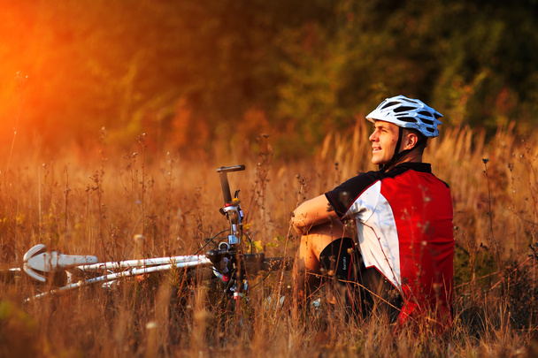 cyclist with bike relax in the sunny autumn park - 写真・画像
