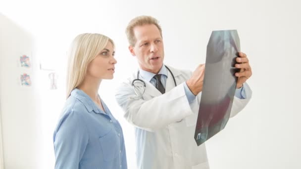Lääkäri keskustelee röntgenkuvasta potilaansa kanssa.
. - Materiaali, video