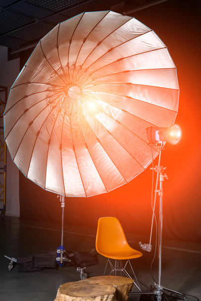 Empty photo studio with modern interior and lighting equipment. Preparation for studio shooting: empty chair and studio lighting. - 写真・画像