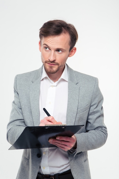 Businessman writing notes in clipboard - Photo, Image