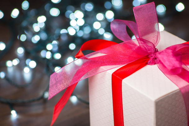 Karácsonyi ajándék doboz-val piros orr és lámpák, fa felületre - Fotó, kép