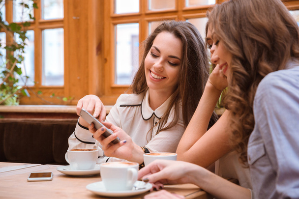 Women using smartphone in cafe  - Foto, imagen