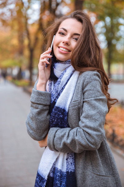 Woman talking on the phone outdoors  - Fotografie, Obrázek