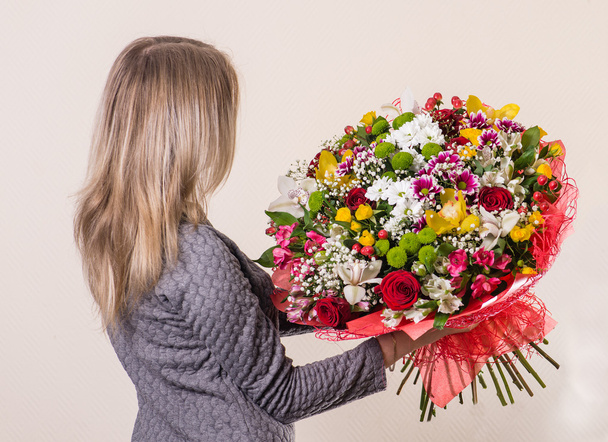 girl with brown hair with a beautiful bouquet in hand back to th - Foto, Imagem