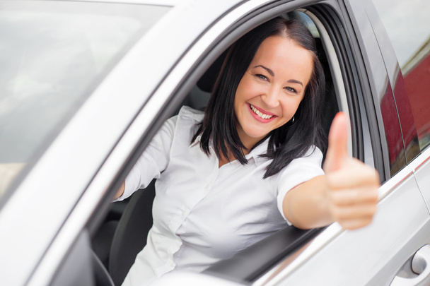 Female driver showing thumbs up - Foto, afbeelding