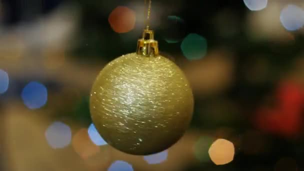 Christmas golden ball rotates at background bokeh - Footage, Video