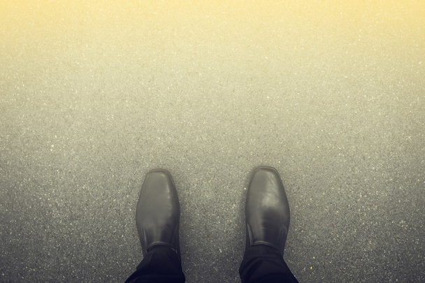 Μαύρα παπούτσια που στέκεται στο πάτωμα και το φως στο μπροστινό μέρος - Φωτογραφία, εικόνα