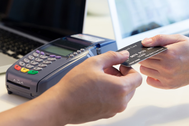 woman swipes her credit card to make the payment - Φωτογραφία, εικόνα