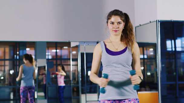 Attraktive Frau macht Übungen mit Kurzhanteln - Filmmaterial, Video