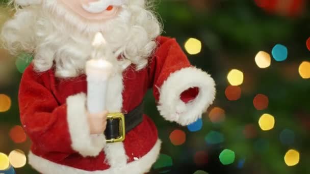 Zabawka Santa Claus przenosi na tle bokeh świateł - Materiał filmowy, wideo