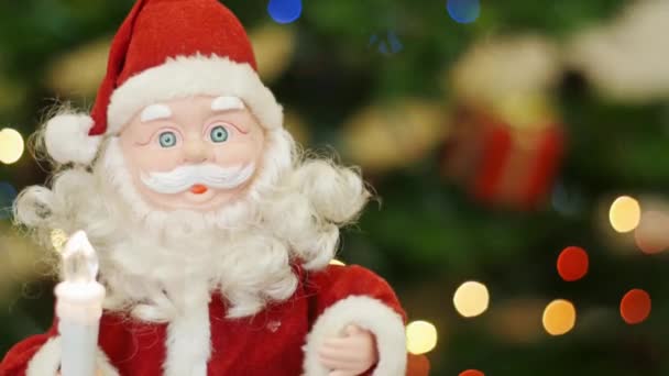 Toy Santa Claus greetings at background bokeh - Footage, Video
