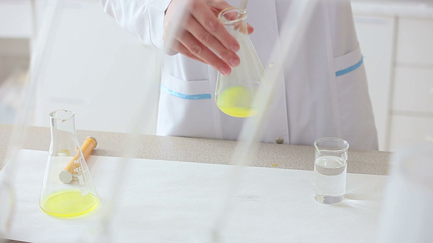 Tutkija työskentelee nesteiden kanssa kemiallisessa laboratoriossa
 - Materiaali, video