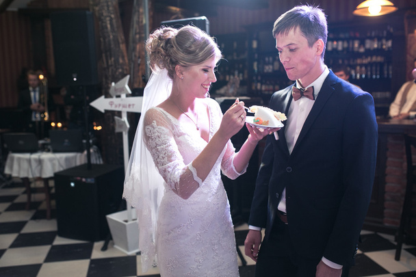 Noiva e noivo estão comendo bolo
 - Foto, Imagem