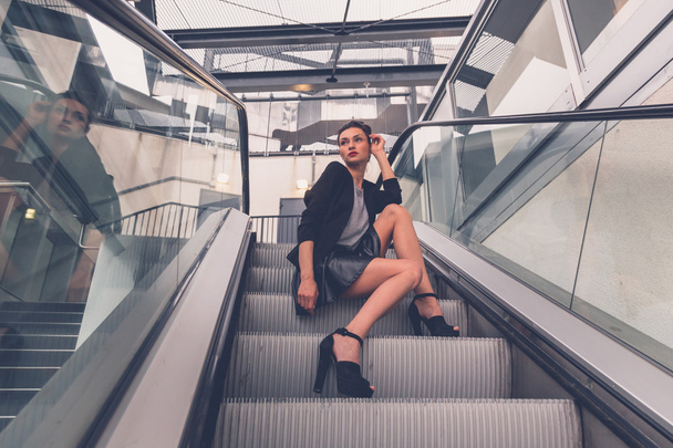 Beautiful girl posing on an escalator - Foto, imagen