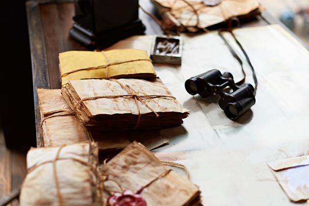Lechuzas viejas, prismáticos y cenicero en un escritorio
 - Foto, imagen