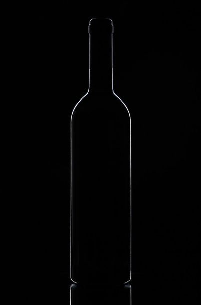 Wine bottle on a black background - Фото, изображение