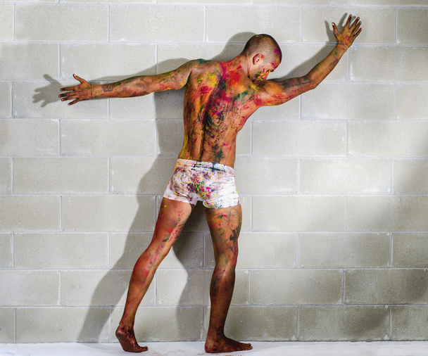 aantrekkelijke jonge man met de huid geschilderd met holi kleuren - Foto, afbeelding