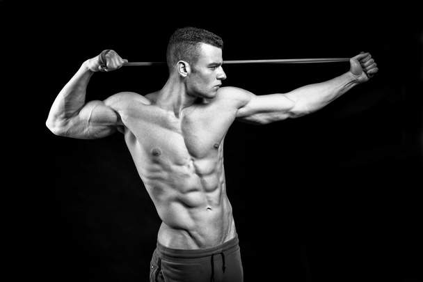 Muscular fitness man presents his body building on black backgro - 写真・画像