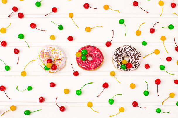 Donuts délicieux colorés décorés avec cerise colorée
 - Photo, image