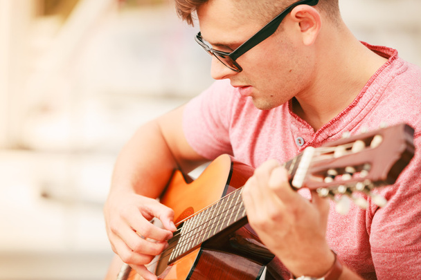Chico de moda con guitarra al aire libre
 - Foto, imagen