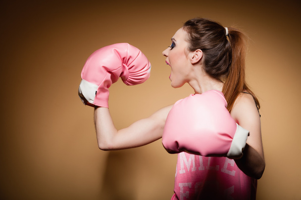 Female boxer wearing big fun pink gloves playing sports - Фото, зображення