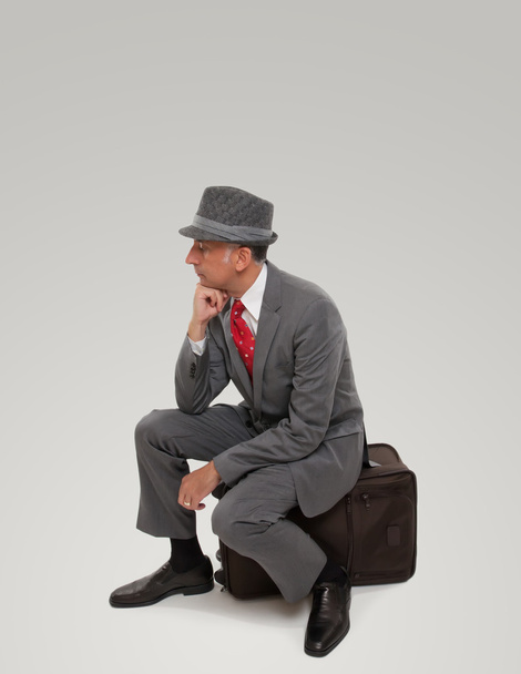 A business traveler waiting seating on a suitcase - Photo, image
