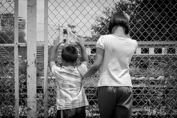 Asyalı kız ve çocuk üzücü el demiryolu, tren stati hapiste tutun - Fotoğraf, Görsel