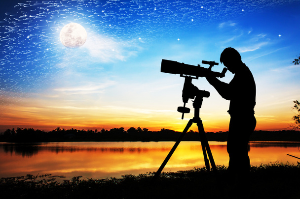 完全に望遠鏡を通して見る若い男のシルエット  - 写真・画像
