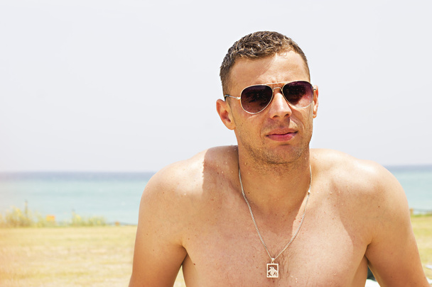 Portrait of an attractive young man on a beach. - Fotografie, Obrázek