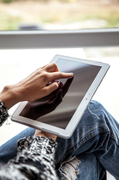 femme tenant et utilisant la tablette avec écran vide, jeans déchiré
 - Photo, image