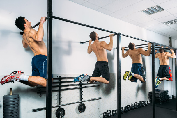 Group of Muscular Men Doing Pull Ups as part of Crossfit Training. - 写真・画像