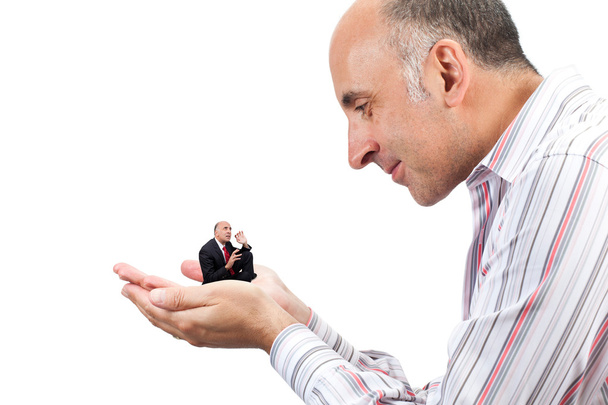 Homme tenant une petite version de lui-même dans sa main
 - Photo, image