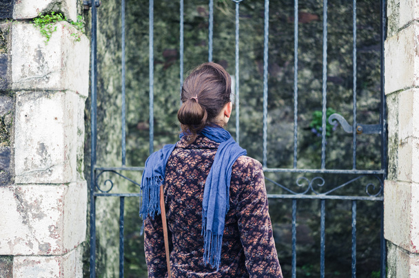 Young woman standing outside some gates - Foto, Bild