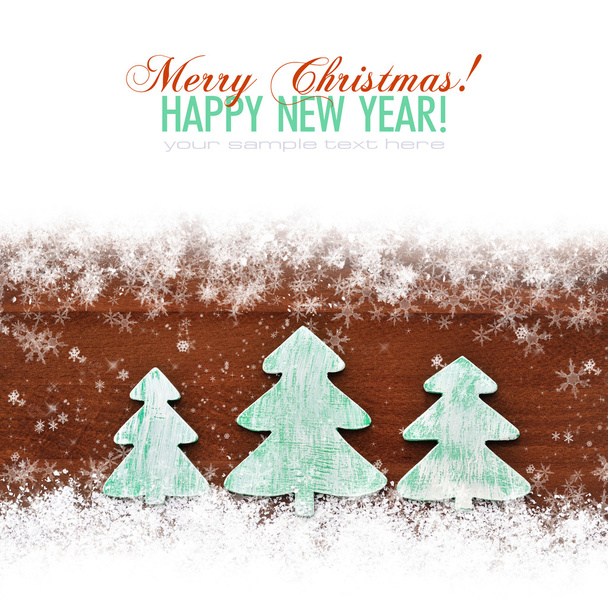 Wooden christmas trees on snow wooden background. Christmas card - Photo, Image
