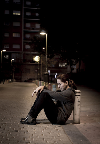 junge traurige Frau, die nachts allein auf der Straße sitzt und verzweifelt unter Depressionen leidet, verlassen - Foto, Bild