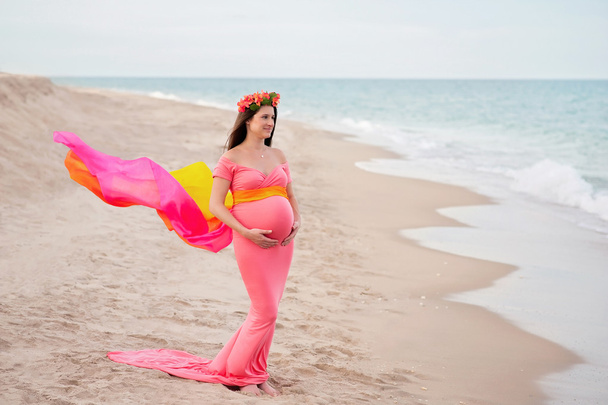 Usmívající se těhotná žena na pláži - Fotografie, Obrázek