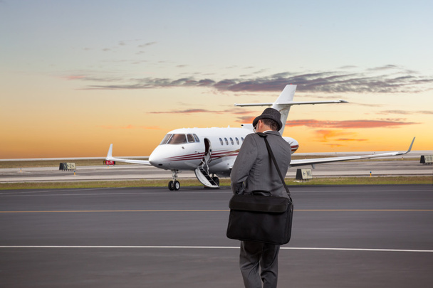 Business man walking toward a private jet - Foto, afbeelding